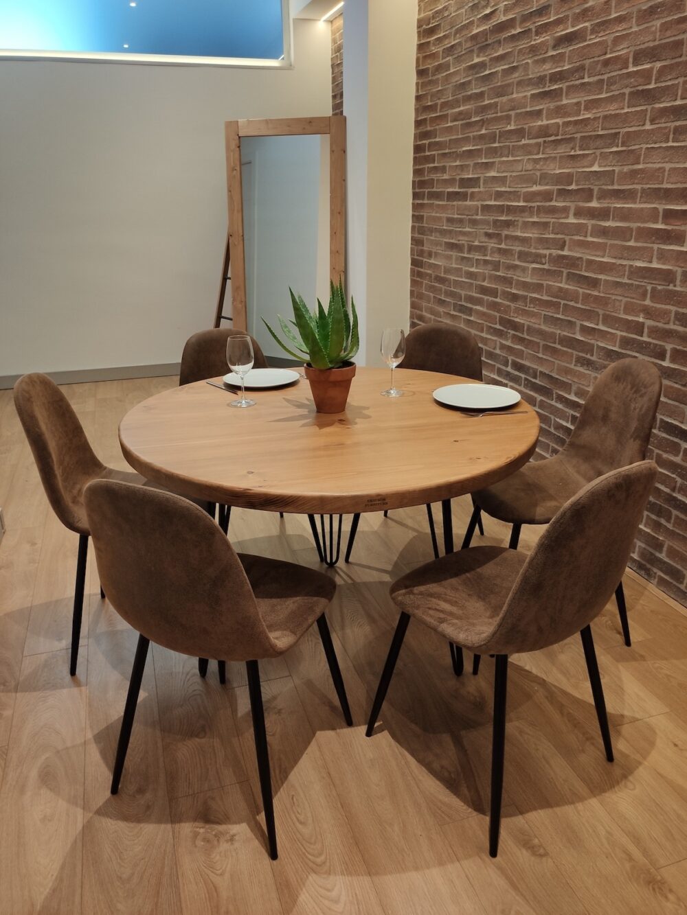 Mesa redonda de madera maciza con 6 sillas alrededor en un salón de estilo industrial