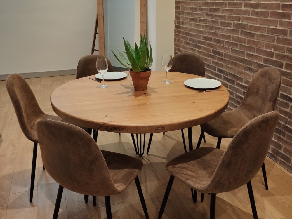 Mesa redonda de madera maciza con 6 sillas alrededor en un salón de estilo industrial