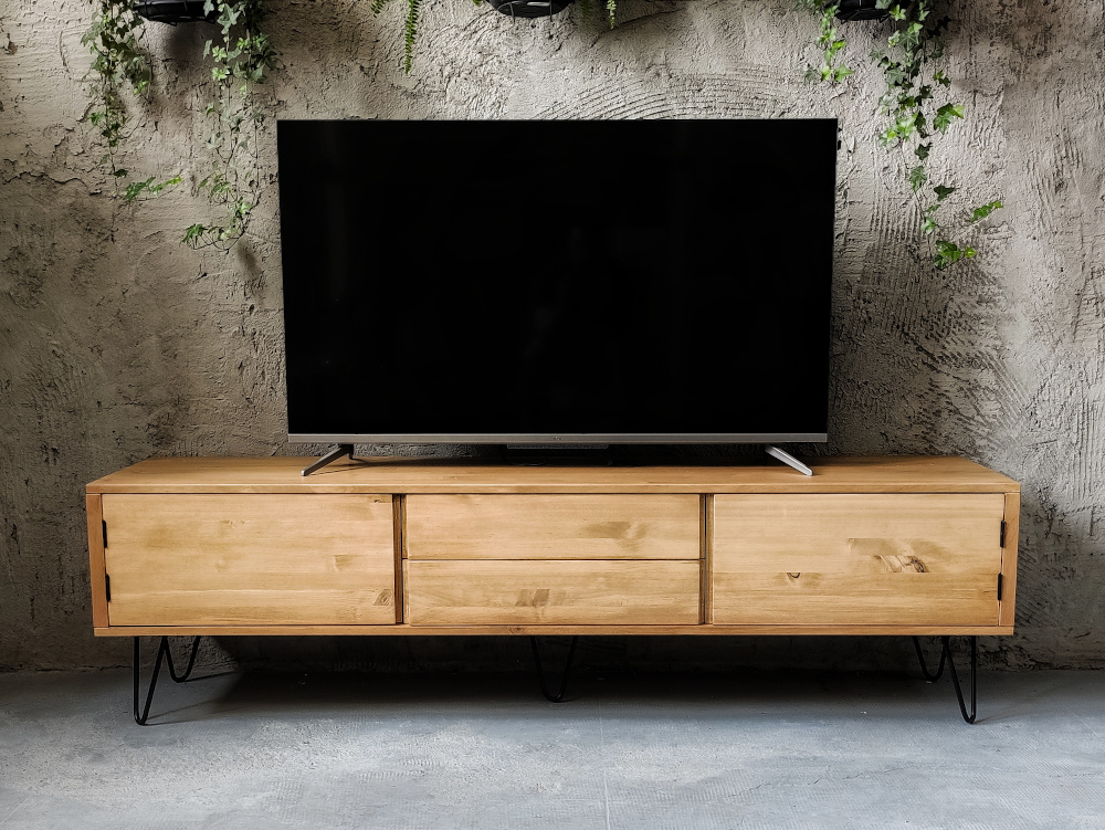 Mueble de tv en madera maciza Grimån con 3 módulos para guardar diferentes cosas en un fondo gris con toques naturales