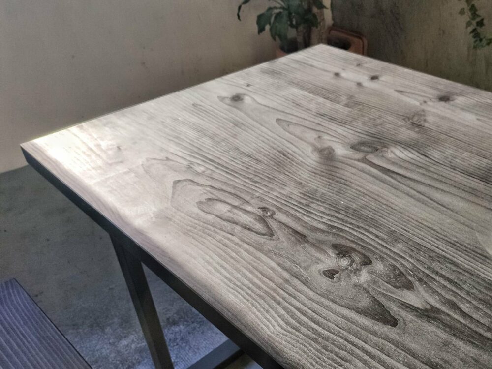 Mesa comedor en madera maciza Svart, formada con el tratamiento Intense Black que subraya los nudos y le da este aspecto tan sólido e industrial a la vez.